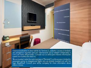 a hotel room with a desk and a tv at TRYP BY WYNDHAM São Paulo Airport - Hotel de Transito Terminal 3 INTERNACIONAL - Lado Ar - Área restrita á passageiros já embarcados e sem bagagens para despachar - Transit Hotel, only carry-on in Guarulhos