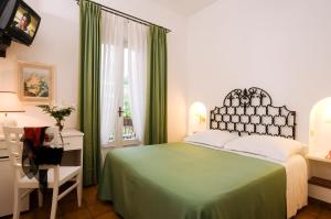 a bedroom with a green bed and a desk at Hotel Villa Angelica in Ischia