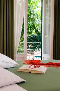 a book and glasses on a bed with a window at Hotel Villa Angelica in Ischia