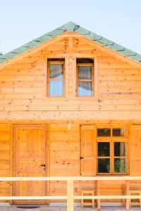 a wooden cabin with windows and a pitched roof at Nashos Bungalows in (( Spile ))