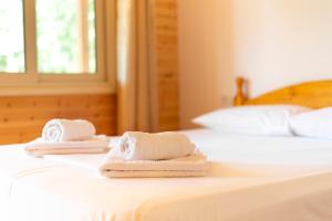 two towels sitting on top of a bed at Nashos Bungalows in (( Spile ))
