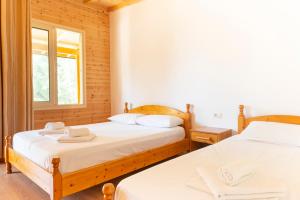 a bedroom with two beds and a window at Nashos Bungalows in (( Spile ))
