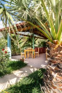 a table and chairs under a pavilion in a garden at Nashos Bungalows in (( Spile ))