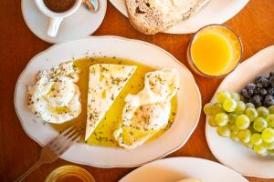 a plate of food with eggs and grapes on a table at Nashos Bungalows in (( Spile ))