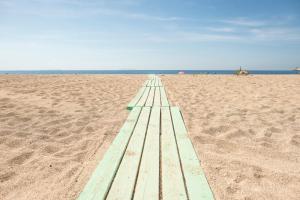 a wooden boardwalk on a sandy beach at Nashos Bungalows in (( Spile ))