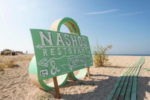 a sign on the beach next to the ocean at Nashos Bungalows in (( Spile ))