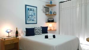 a bedroom with a white bed and a window at Natal Prime Apartments -Porto Imperial in Natal