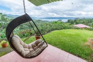 a hammock on a patio with a view of a yard at Nepenthe B&B in El Castillo de La Fortuna