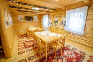 a dining room with wooden tables in a cabin at Casutele Din Moisei in Moisei