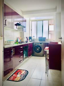 cocina con lavadora y mesa en Marbella Beach location pour famille 2 chambres en Minaret de Mansuria