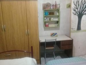 a bedroom with a desk with a chair and a cabinet at HOSTEL la Casa del Patio BB in Bahía Blanca