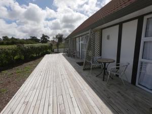 a wooden deck with chairs and a table on a house at Castle Court Motel in Wellsford