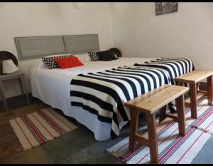 uma cama grande com lençóis pretos e brancos num quarto em Herdade da Carapuça em Portalegre