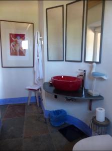 Un baño con un lavabo rojo en una encimera. en Herdade da Carapuça, en Portalegre