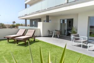 a patio with two benches and grass at TEJITA BEACH APARTMENT in El Médano