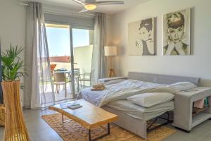 a bedroom with a bed and a living room with a table at TEJITA BEACH APARTMENT in El Médano +21 photos