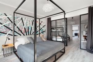 Schlafzimmer mit Himmelbett und Wandgemälde in der Unterkunft NAP Apartments Długie Ogrody in Danzig
