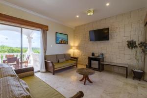 un soggiorno con divano e TV di Cielo Maya Beach Tulum a Tulum
