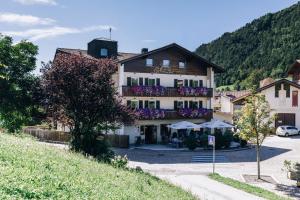 ein Gebäude mit Blumen auf den Balkonen in einem Dorf in der Unterkunft Hotel Schönwies in Truden