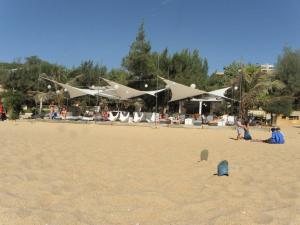 a group of people on a beach with white umbrellas at Villa JAJA Piscine-Climatisation in Poponguine