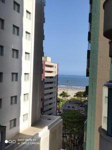 un balcón con vistas a un edificio y a la playa. en Residencial Estanconfort Santos en Santos