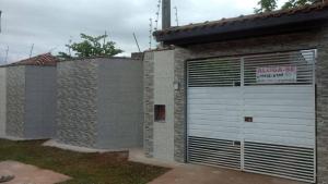 a building with a garage door with a sign on it at Pousada Boracéia 1 - Bertioga in Boracéia