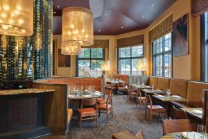 a restaurant with tables and chairs and windows at The Sebastian - Vail in Vail