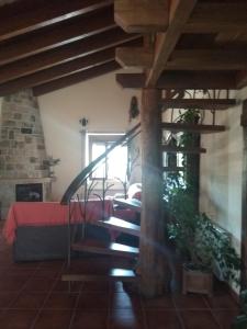 a living room with a spiral staircase in a house at Entre las Piedras y musgo in Muñopepe