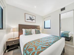a bedroom with a large bed and a large window at Quest River Park Central in Brisbane