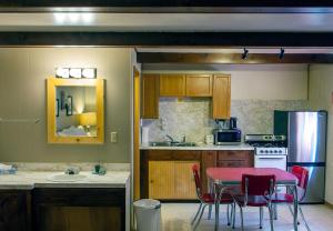 a kitchen with a red table and chairs in it at High Country Motel and Cabins in Cooke City