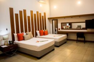 a hotel room with two beds and a mirror at Colina de Montalva Casa Hotel in Tarapoto