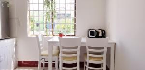 順化的住宿－Chic Studio Homestay，厨房配有桌椅和窗户。