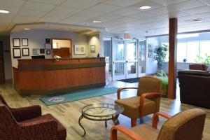 a lobby with a waiting area with chairs and a desk at Inn at the Finger Lakes in Auburn