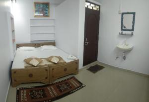 a bedroom with a bed and a sink and a bathroom at Ganga Paying Guest House in Varanasi