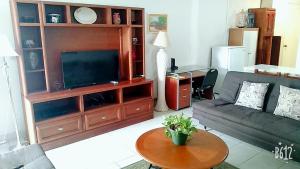 a living room with a couch and a flat screen tv at CONDOMINIO SÁBALO VISTA in Mazatlán