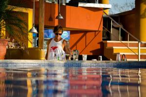 una persona de pie junto a una piscina en Hotel Vista de Olas, en Santa Teresa Beach