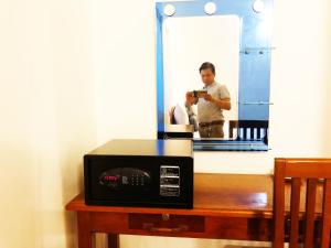 a man taking a picture of a microwave in front of a mirror at Blossoming Romduol Boutique in Siem Reap