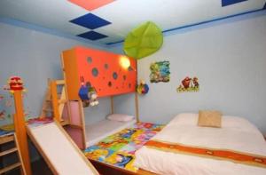 冬山鄉的住宿－101親子溜滑梯民宿 ，一间卧室配有一张床和一张双层床。