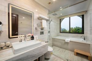 a bathroom with a sink and a tub and a toilet at The Oriental Jade Hotel in Hanoi