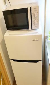a microwave sitting on top of a white refrigerator at ピオーレ大手門402 in Fukuoka