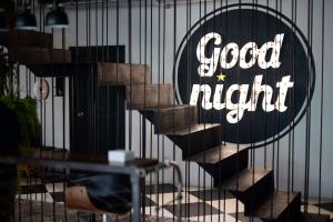 una cerca con una buena señal de noche en ella en Goodnight Poshtel + Free Netflix en Hat Yai