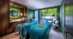 a room with three beds with blue sheets and a mirror at Hard Rock Hotel Desaru Coast in Desaru