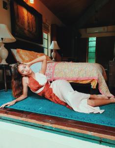 a woman laying on top of a bed at Havana Pool Villa in Ban Huai Yai