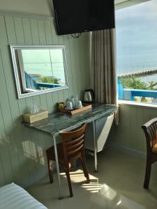 a table and chairs in a room with a window at PierView Rooms in Hua Hin