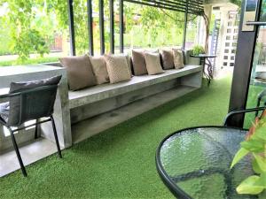 a living room with a couch with green grass at To Bed Poshtel in Chiang Mai
