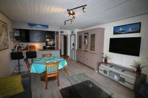 een keuken en een woonkamer met een tafel en een televisie bij Chamonix centre, 51m2, vue Mt Blanc, 2 à 6 pers, 2 balcons in Chamonix-Mont-Blanc