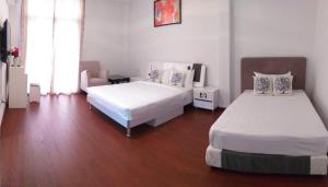 1 Schlafzimmer mit 2 Betten und Holzboden in der Unterkunft Coconut Bay Lodge in Bandar Seri Begawan
