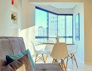 a living room with a table and chairs and a large window at Royal Ibirapuera Park - Flat in Sao Paulo