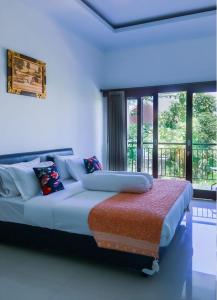 a bedroom with a large bed with a large window at Villa Mahalini Seminyak in Seminyak