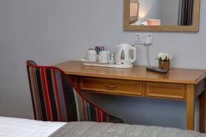 a coffee cup sitting on top of a wooden table at Best Western Stoke on Trent City Centre Hotel in Stoke on Trent